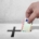 Hand steckt Geldschein in einen Schlitz mit Kreuz, Symbol für Spende